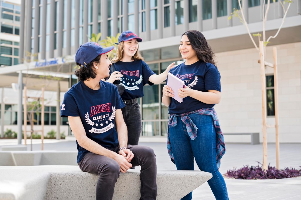 AUBH: students chatting on a bench in the campus courtyard, creative direction by Bashar Daas