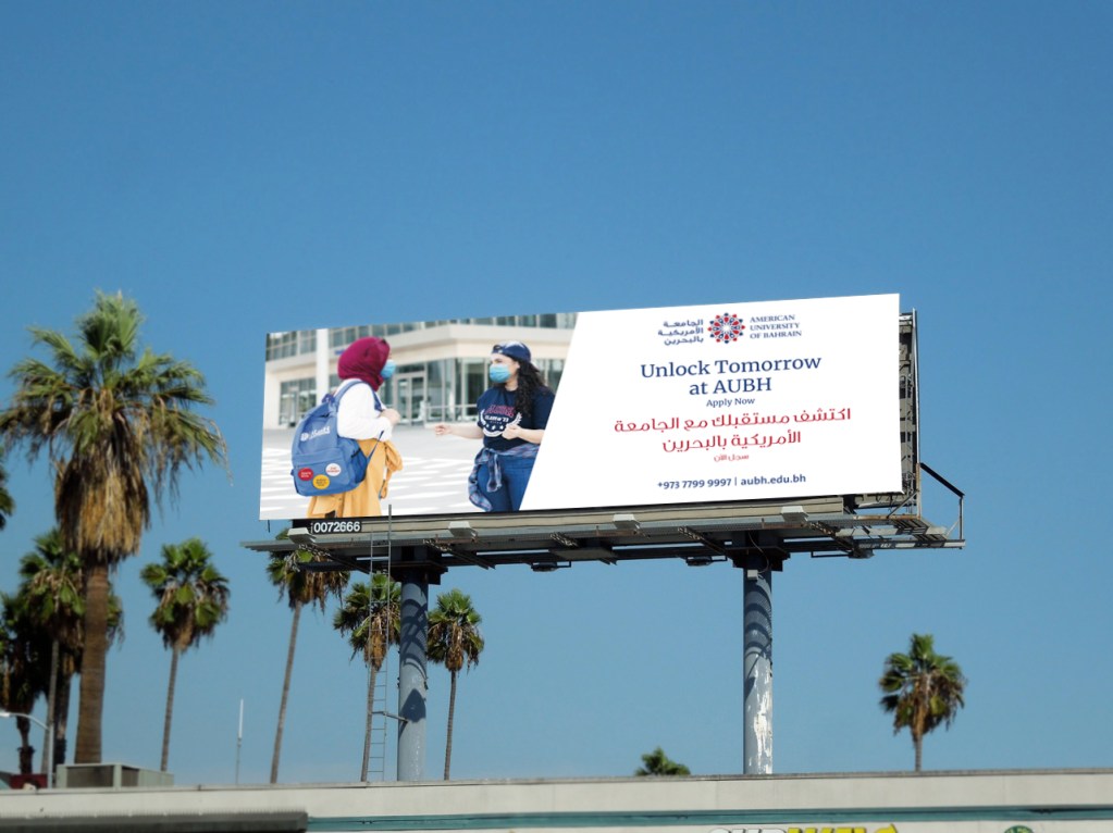 AUBH: bilingual “Unlock Tomorrow at AUBH” billboard against a blue sky, creative direction by Bashar Daas