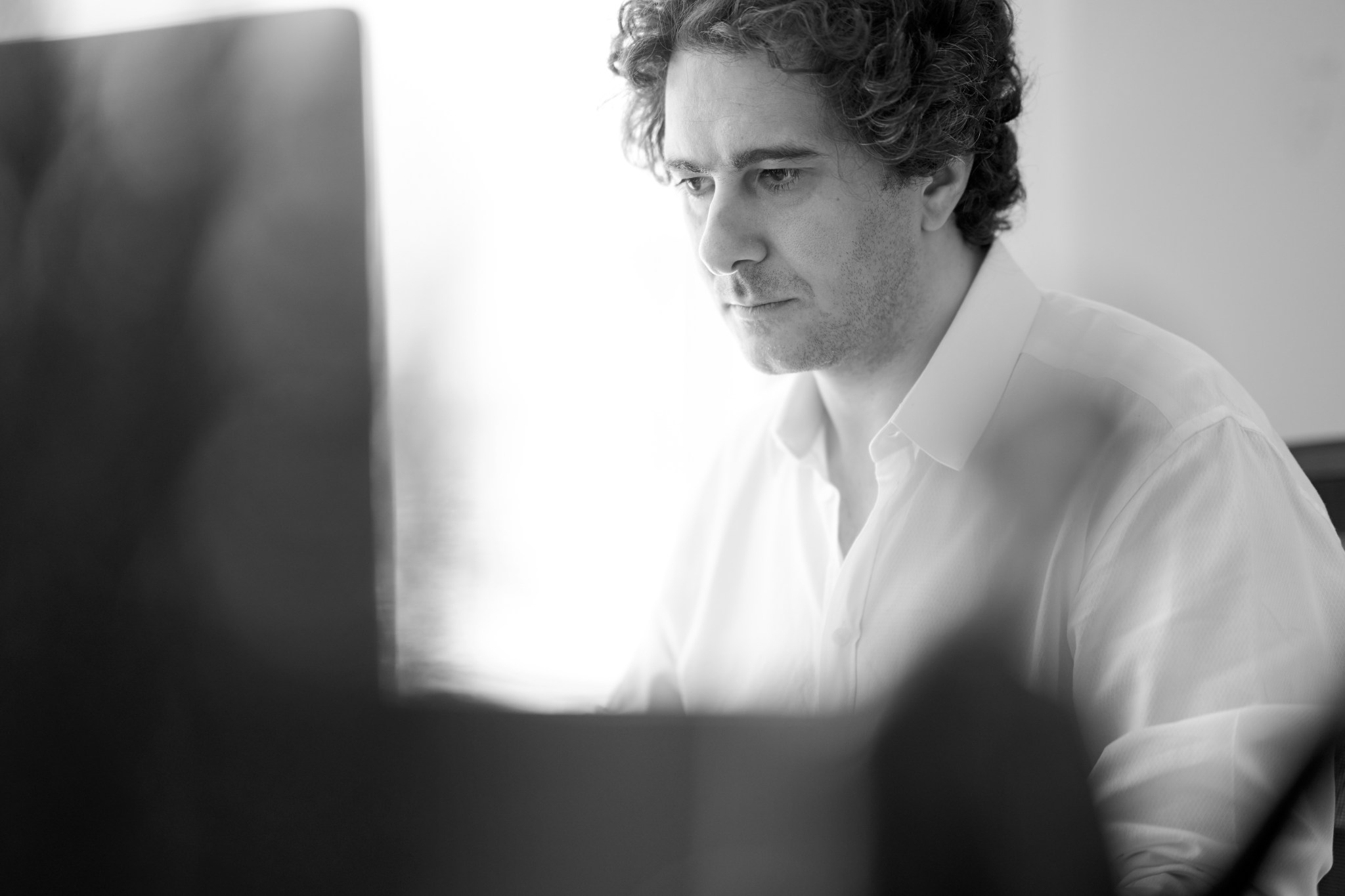 Bashar Daas (Bonfelle) working at a computer, black and white photo