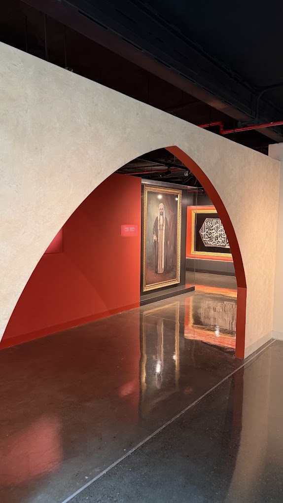 Kanoo Museum: arched passage opening onto a red gallery, creative direction by Bashar Daas
